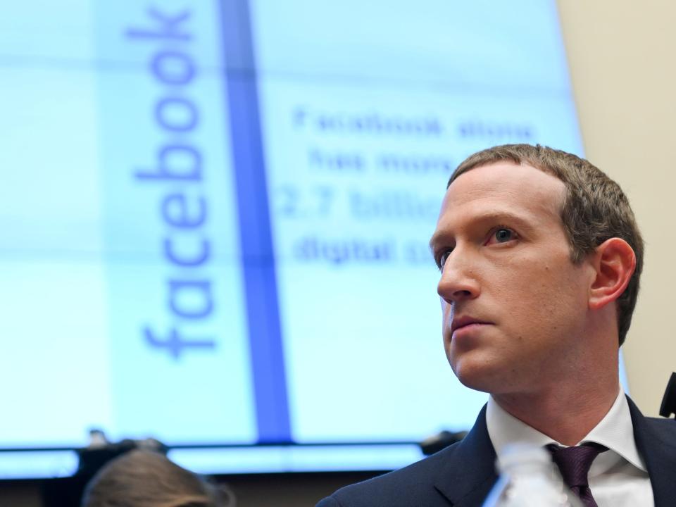 Facebook Chairman and CEO Mark Zuckerberg testifies at a House Financial Services Committee hearing in Washington, U.S., October 23, 2019, wearing a suit and looking serious with facebook logo in background.
