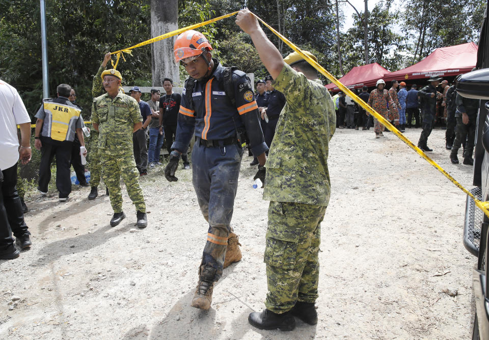 Rescue team gather at a control post near the site of a landslide at an organic farm in Batang Kali, Malaysia, Friday, Dec. 16, 2022. Dozens of Malaysians were believed to have been at a tourist campground in Batang Kali, outside the capital of Kuala Lumpur, when the incident occurred, said a district police chief. (AP Photo/FL Wong)