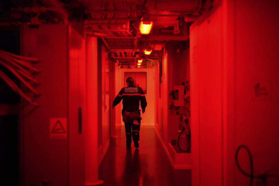 A French sailor walks on a corridor of the French navy frigate Normandie as the vessel patrols in a Norwegian fjord, north of the Arctic circle, for a reconnaissance patrol, Wednesday March 6, 2024. The French frigate is part of a NATO force conducting exercises in the seas, north of Norway, codenamed Steadfast Defender, which are the largest conducted by the 31 nation military alliance since the cold war. (AP Photo/Thibault Camus)