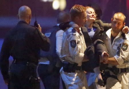 Police rescue personnel carry an injured woman from the Lindt cafe, where hostages are being held, at Martin Place in central Sydney December 16, 2014. REUTERS/Jason Reed