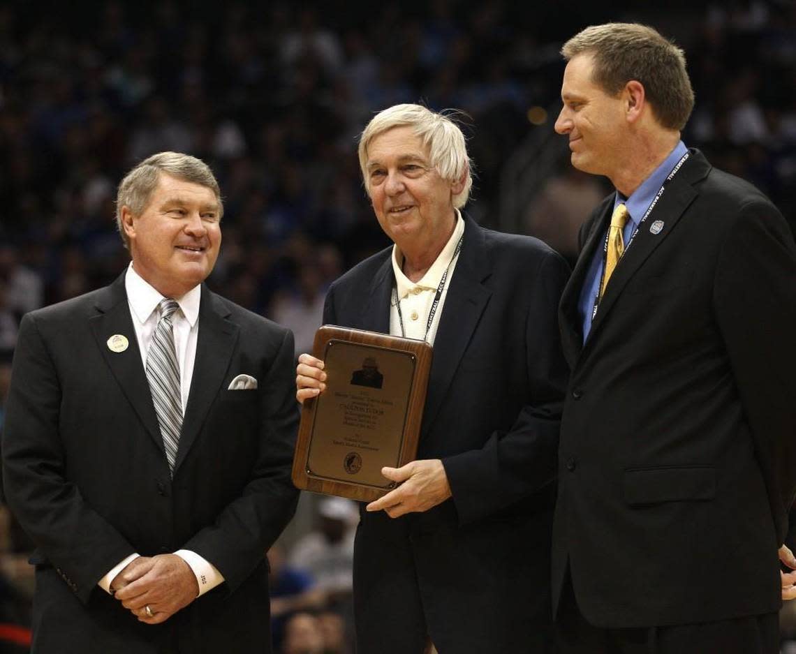News & Observer columnist Caulton Tudor, center, accepts the Atlantic Coast Sports Media Association’s Skeeter Francis Award from ACC Commissioner John Swofford, left, during the ACC basketball tournament in Atlanta, Ga. on March 10, 2010.
