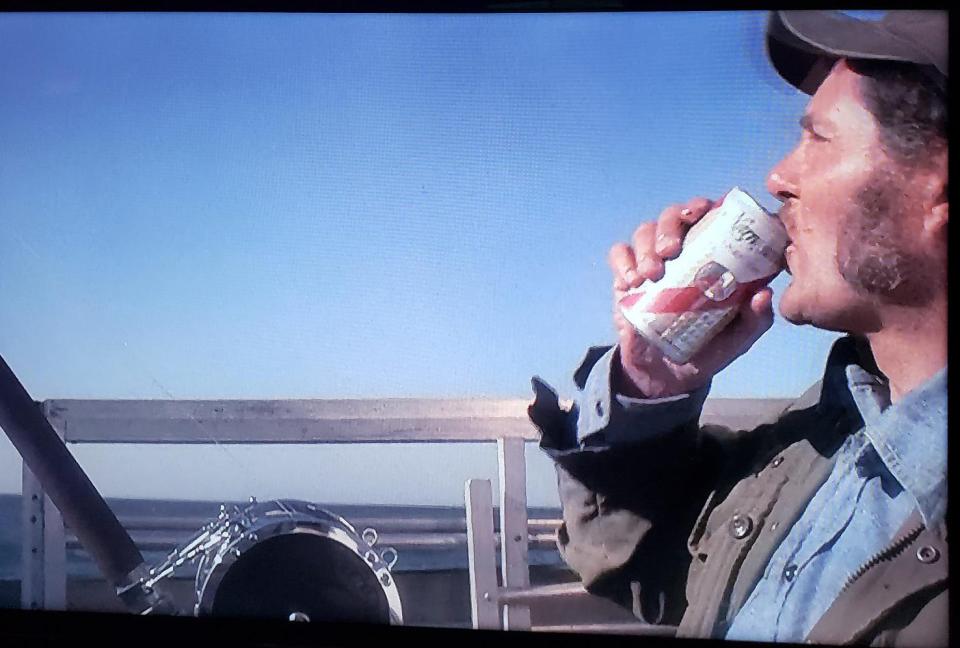 Captain Quint, aboard the Orca, enjoying a 'Gansett before facing a great white shark in "Jaws."