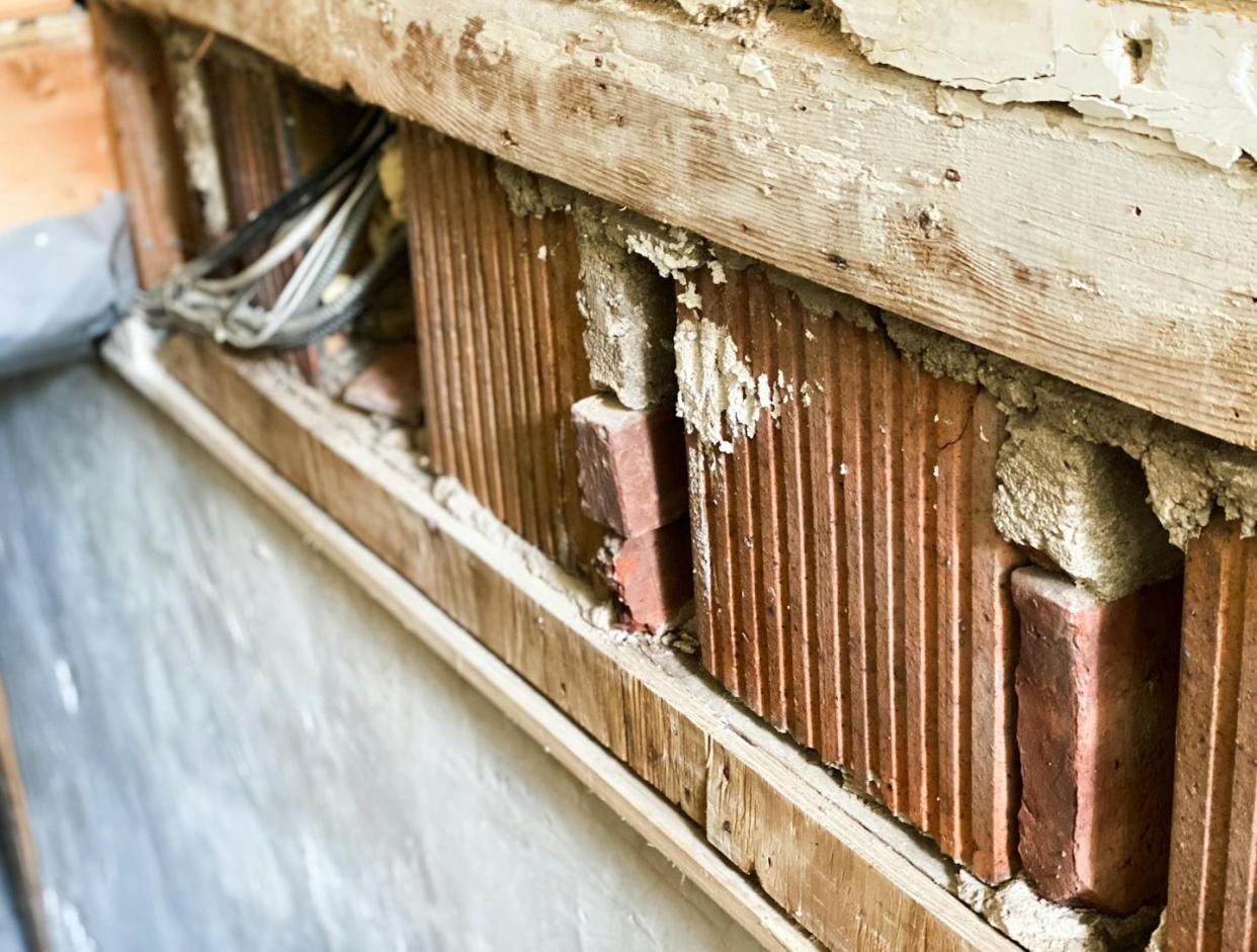 The removal of drywall during mold remediation is seen after a basement flood. <a href="https://www.gettyimages.com/detail/photo/removal-of-drywall-along-staircase-leading-to-house-royalty-free-image/1345055192?phrase=home%20repairs%20disaster&adppopup=true" rel="nofollow noopener" target="_blank" data-ylk="slk:Catherine McQueen/Getty Images;elm:context_link;itc:0;sec:content-canvas" class="link ">Catherine McQueen/Getty Images</a>