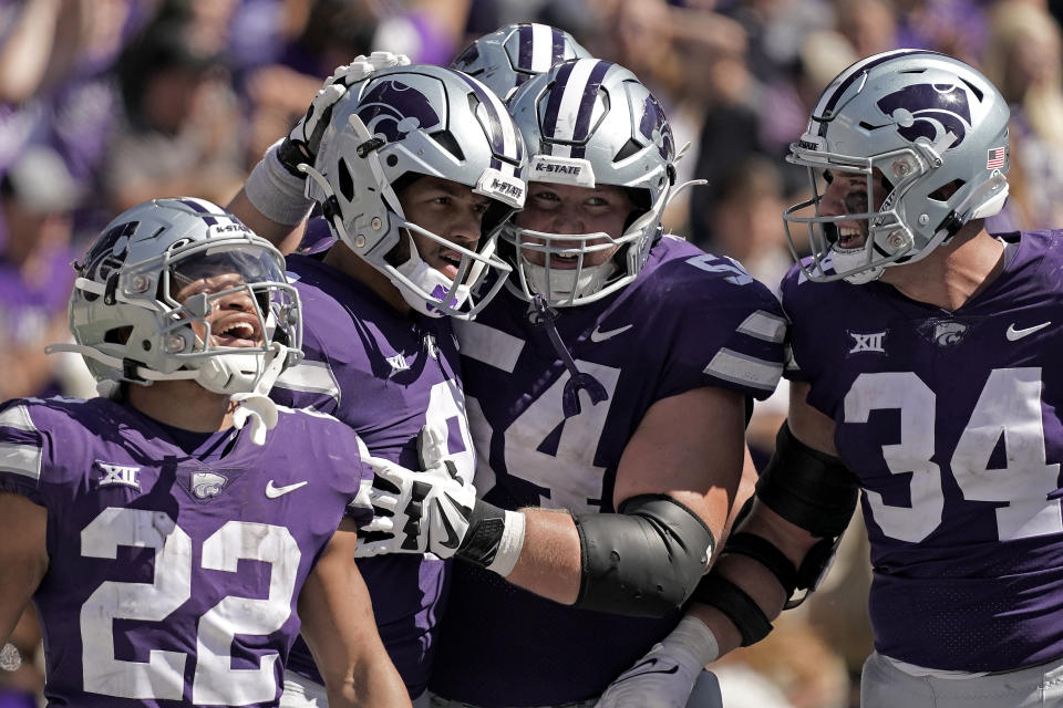 Kansas State quarterback Adrian Martinez, second from left, celebrates with teammates after scoring a touchdown during the second half of an NCAA college football game against Texas Tech Saturday, Oct. 1, 2022, in Manhattan, Kan. Kansas State won 37-28. (AP Photo/Charlie Riedel)