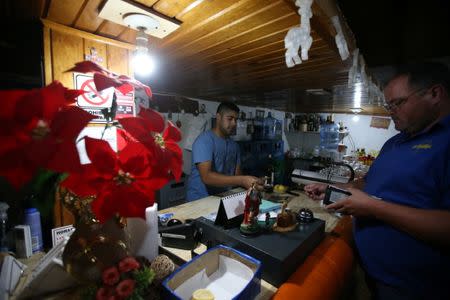 Carlos Gonzalez attends to a customer at a restaurant in Las Lajas, Argentina, January 22, 2019. REUTERS/Agustin Marcarian