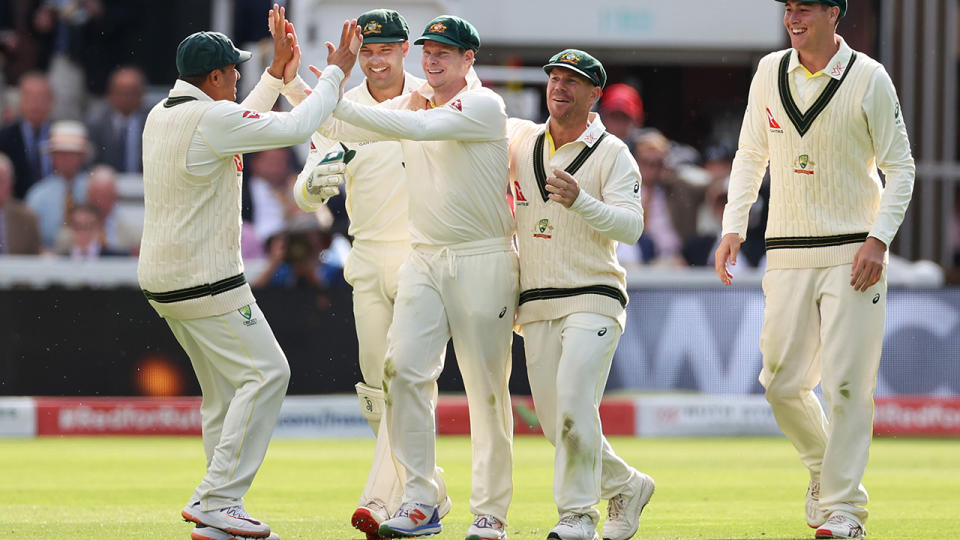 Australian players celebrate with Steve Smith after his catch to dismiss Joe Root.