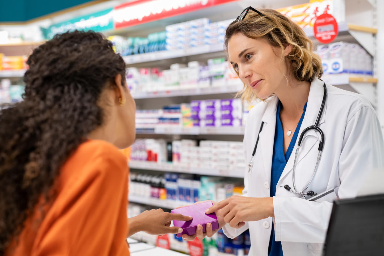 Pharmacist giving medicine box to customer in pharmacy. (Getty Images)