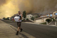 <p>Manuel Trujillo packs his belongings as flames of Holy Fire came very close to his home on 29000 block of Sandpiper Drive in Lake Elsinore, Calif., on Aug. 9, 2018. (Photo: Irfan Khan/Los Angeles Times via Getty Images) </p>