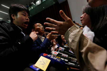 Pro-democracy lawmakers (R) argue with pro-Beijing lawmakers (L) after the latter staged a walk-out to stall activists Baggio Leung and Yau Wai-ching from swearing in at the Legislative Council in Hong Kong, China October 19, 2016. REUTERS/Bobby Yip