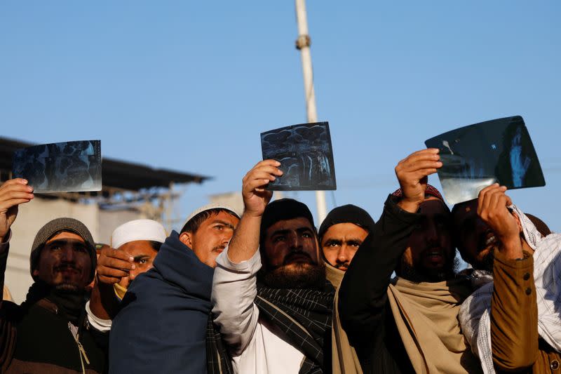 People use x-ray sheets as they observe the solar eclipse in Peshawar