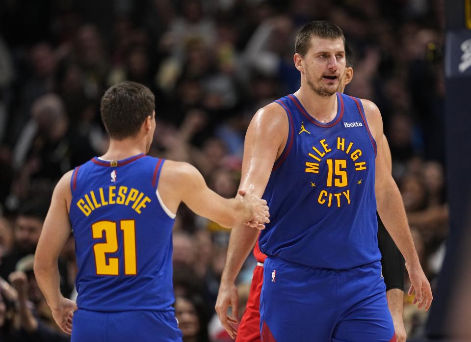 Denver Nuggets center Nikola Jokic (15) celebrates a basket against the Chicago Bulls with teammate Collin Gillespie (21) during the third quarter of an NBA basketball game, Saturday, Nov. 4, 2023, in Denver. (AP Photo/Jack Dempsey)