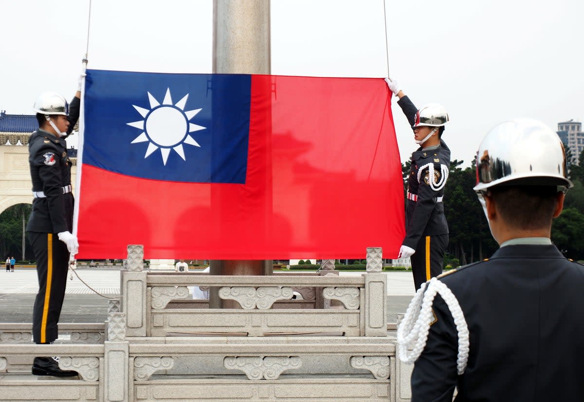 Soldiers hoist the flag of Taiwan in Taipei (EPA)