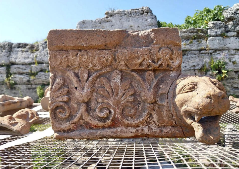 This undated photo shows an architectural element with a leonine protome drip found in a newly discovered sanctuary, which dates from the 5th century B.C., that was first identified in 2019 along the ancient city walls of Paestum, Southern Italy. The excavations of the sanctuary in the ancient city of Paestum have unearthed seven terracotta bull heads and a figurine of Eros riding a dolphin that shines new light on the religious life and rituals of the ancient Greek city, culture ministry officials said Saturday, April 15, 2023. (Paestum Velia Archeological Park via AP)