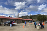 Medical workers and volunteers administer the coronavirus vaccine at a drive-thru immunization clinic at an inn and RV park in Mora, N.M., on Tuesday, April 20, 2021. New Mexico is among the states with the highest rates of vaccination for COVID-19. Vaccine crews also traveled down dirt roads to visit homebound elderly residents in sprawling Mora County, with just 4,500 residents who are 80% Latino. First Lady Jill Biden was kicking off of a visit to the U.S. Southwest with a tour of a vaccination clinic in Albuquerque. (AP Photo/Morgan Lee)