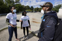 Wendy Caldwell-Liddell, from left, who helped start Mobilize Detroit, and Paris Powell talk with a voter in Detroit, Friday, Sept. 18, 2020. Both President Donald Trump and Democratic presidential nominee Joe Biden are battling for support among Black voters across Michigan, and Biden's running mate, Sen. Kamala Harris, will be in the state on Tuesday, Sept. 22. (AP Photo/Paul Sancya)