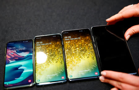 A Samsung employee arranges the new Samsung Galaxy S10e, S10, S10+ and the Samsung Galaxy S10 5G smartphones at a press event in London, Britain February 20, 2019. REUTERS/Henry Nicholls