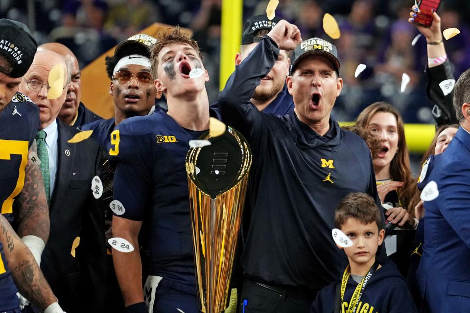 Michigan head coach Jim Harbaugh and wide receiver Cornelius Johnson celebrate Monday night's 34-13 win over Washington in the CFP championship game at NRG Stadium. "It went exactly  how we wanted it to go," Harbaugh said.