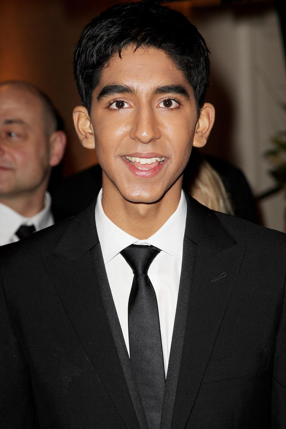 Closeup of a much younger Dev Patel in a suit and tie