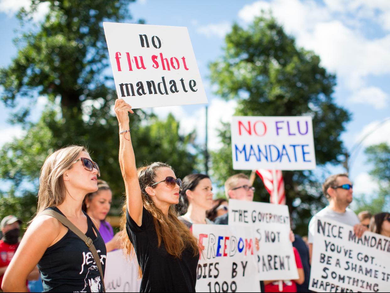 Anti-vaccine activists hold signs in front of the Massachusetts State House during a protest against mandatory vaccines (Getty Images)