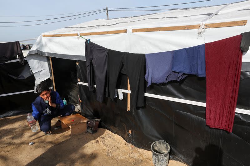 Ahmed Jarbou, un niño palestino desplazado cuyo padre murió en un ataque israelí, se lava la cara fuera del refugio improvisado de su familia, en Rafah, en el sur de la Franja de Gaza