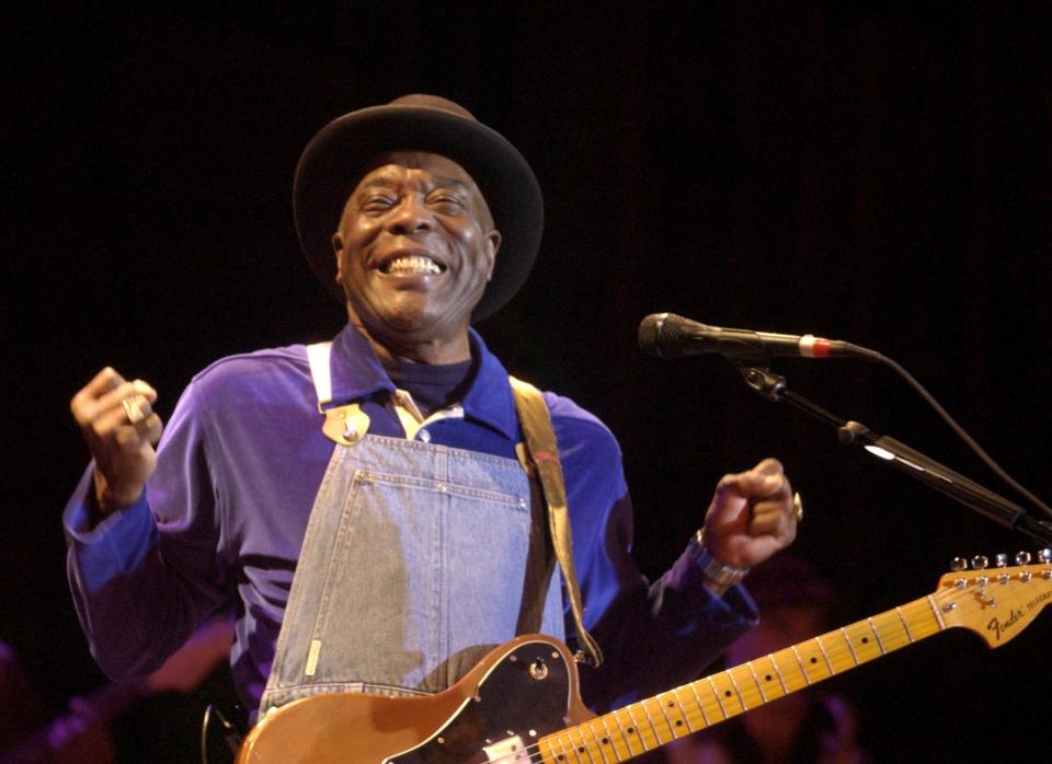 Buddy Guy flashes his trademark smile while wearing his overalls during a performance in Savannah on March 18, 2005.