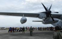 Residents prepare to board a U.S. military C130 aircraft to leave for Manila after the Super typhoon Haiyan battered Tacloban city in central Philippines November 11, 2013. Dazed survivors begged for help and scavenged for food, water and medicine on Monday, as relief workers struggled to reach victims of a super typhoon that killed an estimated 10,000 people in the central Philippines. REUTERS/Edgar Su (PHILPPINES - Tags: DISASTER ENVIRONMENT)