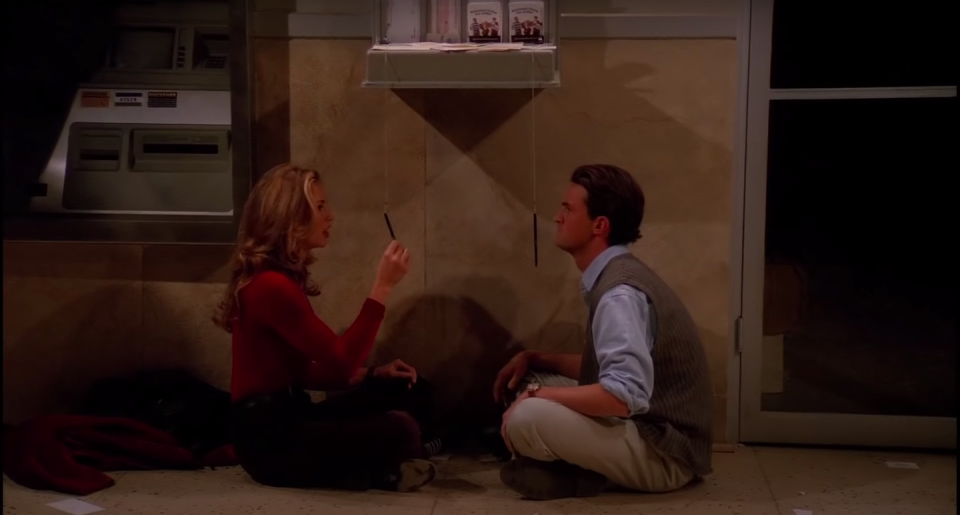 Chandler and Jill Goodacre sit on the ATM vestibule floor, playing with the ATM pens