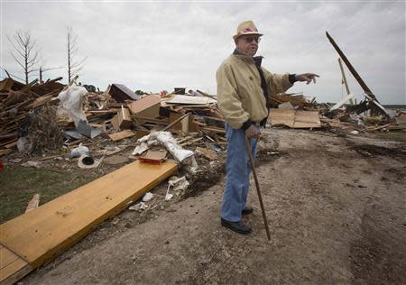 Darwin Henry points across the street as the talks about his neighbor who died in Mayflower, Arkansas April 29, 2014. REUTERS/Carlo Allegri