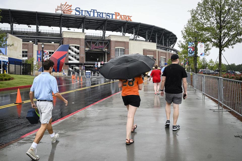 <p>Fans arrive at SunTrust Park for the Atlanta Braves’ baseball game against the San Francisco Giants, June 20, 2017, in Atlanta. Tropical Storm Cindy has been causing rain in much of the Southeast. (Photo: John Amis/AP) </p>