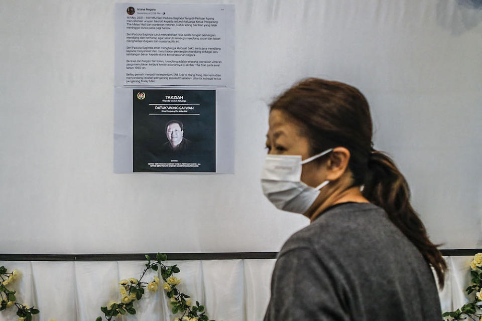 Datuk Wong Sai Wan's wife Loo Poh Ling looks at a printed poster of the Yang di-Pertuan Agong's message of condolence on Facebook to the family at Xiao En Centre in Cheras, Kuala Lumpur May 15, 2021. ― Picture by Hari Anggara