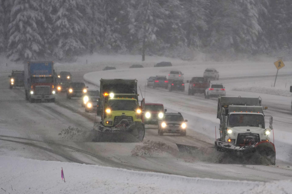 FILE - Washington Dept. of Transportation snow plows work on a stretch of eastbound Interstate Highway 90, Dec. 9, 2021, as snow falls near Snoqualmie Pass in Washington state. Authorities say Snoqualmie Pass in Washington state has received the highest snowfall in 20 years as of Jan. 3, 2022. The Washington State Department of Transportation said by Monday afternoon, Jan. 3, 2022, 236 inches of snowfall was recorded, more than the 229 inches by Jan. 3 that was recorded in 2007 and 212 inches in 2004. (AP Photo/Ted S. Warren, File)