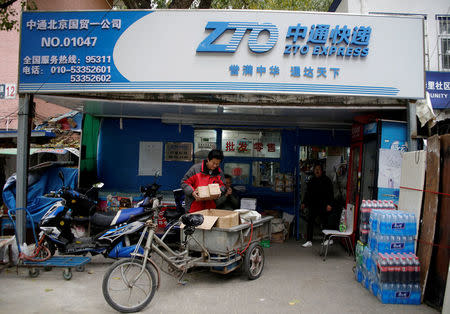 A deliveryman holds parcels at a branch of ZTO Express in Beijing, China October 27, 2016. REUTERS/Jason Lee