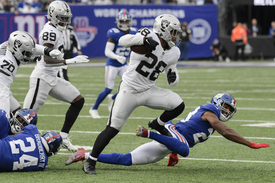 Las Vegas Raiders running back Josh Jacobs (28) breaks a tackle by New York Giants' Adoree' Jackson (22) during the second half of an NFL football game Sunday, Nov. 7, 2021, in East Rutherford, N.J. (AP Photo/Bill Kostroun)