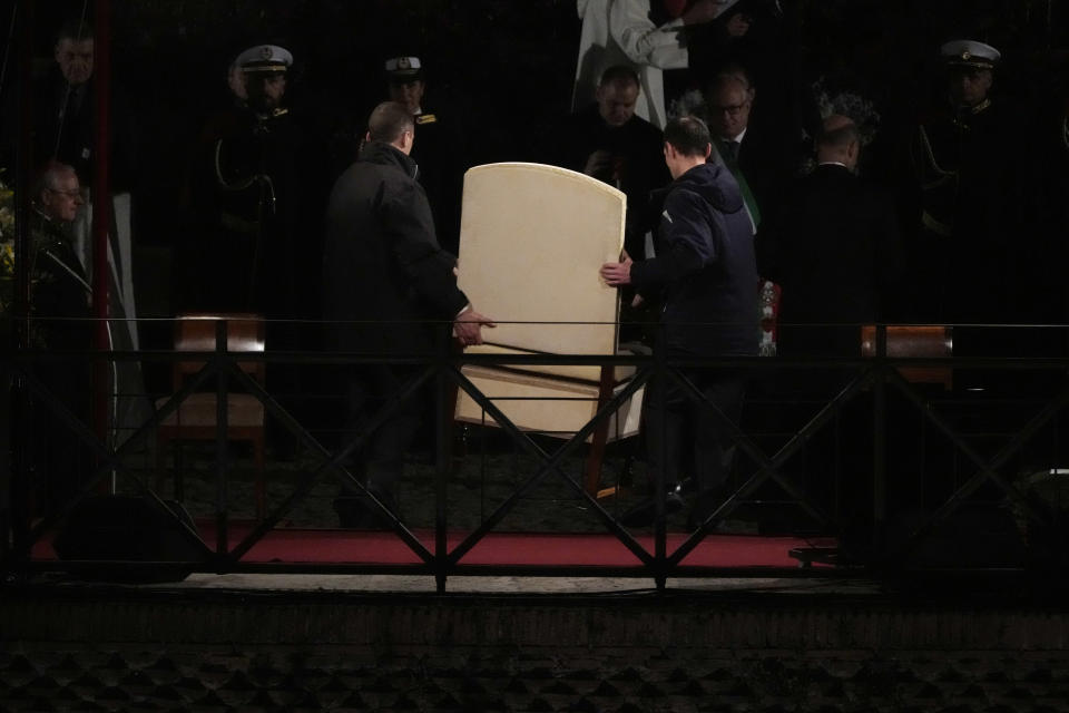 Vatican ushers carry Pope Francis chair prior to the start of the Via Crucis (Way of the Cross) at the Colosseum on Good Friday, in Rome, Friday, March 29, 2024. (AP Photo/Gregorio Borgia)