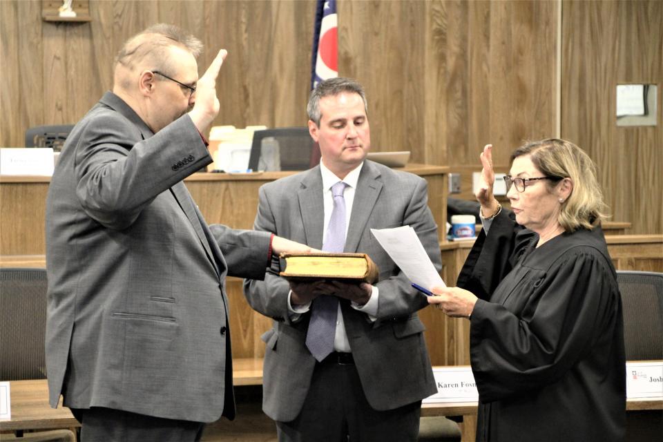 Matthew Pollock, left, recites the oath of office before being seated on Marion City Council on Monday. Municipal Court Judge Teresa L. Ballinger, right, administered the oath. Marion County Prosecutor Ray Grogan holds a bible used for the ceremony.
