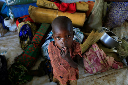 A displaced boy from South Sudan stands next to family belongings in Lamwo after fleeing fighting in Pajok town across the border in northern Uganda April 5, 2017. REUTERS/James Akena