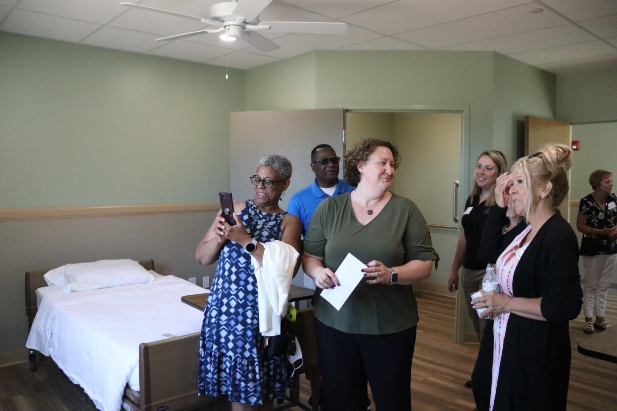 At center, Holly Klein, executive director of Grace House Akron, shows supporters and volunteers a patient room. The hospice's mission is to ensure no one dies alone.