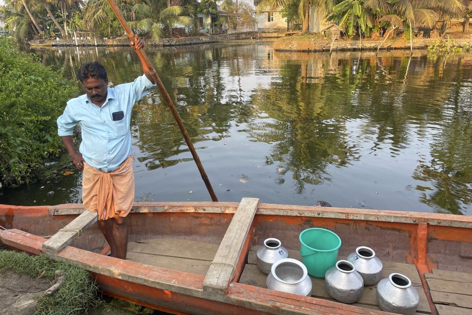 A man stands in his boat with water pots to get them filled in another district in Kochi, Kerala state, India, March 1, 2023. Saltwater's intrusion into freshwater is a growing problem linked to climate change and in Chellanam rising salinity means residents can no longer depend on ponds and wells for the water they need to drink, cook and wash. (Uzmi Athar/Press Trust of India via AP)