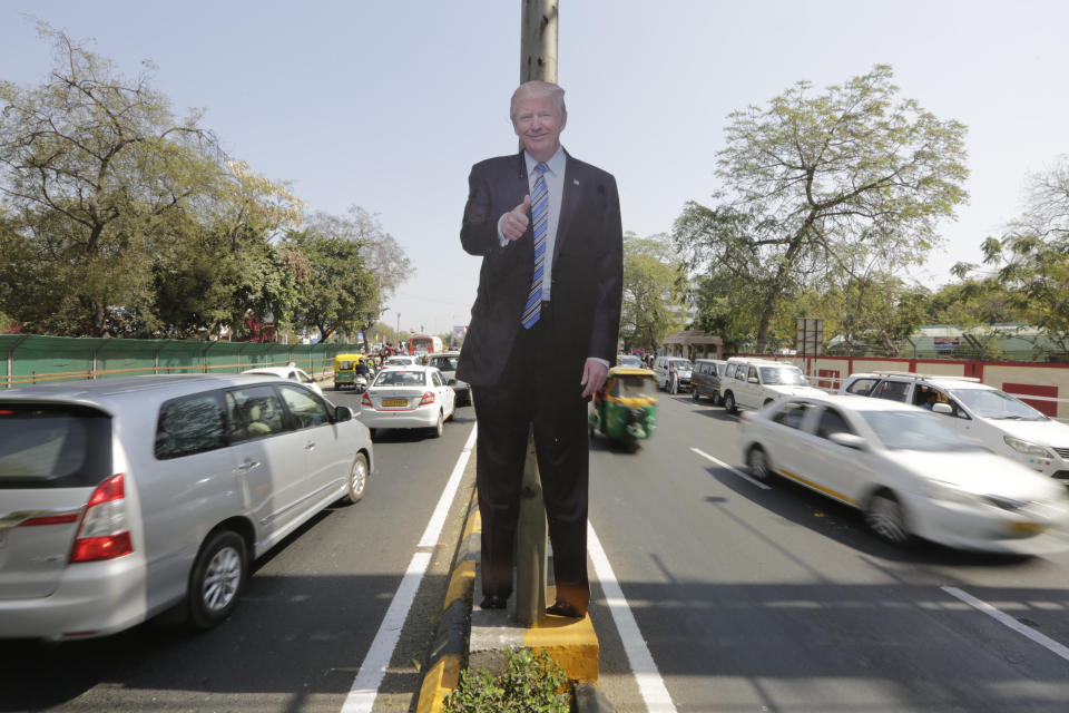 A life size cut-out of U.S. president Donald Trump stands on a road divider, ahead of his visit in Ahmedabad, India, Saturday, Feb. 22, 2020. To welcome Trump, who last year likened Modi to Elvis Presley for his crowd-pulling power at a joint rally the two leaders held in Houston, the Gujarat government has spent almost $14 million on ads blanketing the city that show them holding up their hands, flanked by the Indian and U.S. flags. (AP Photo/Ajit Solanki)