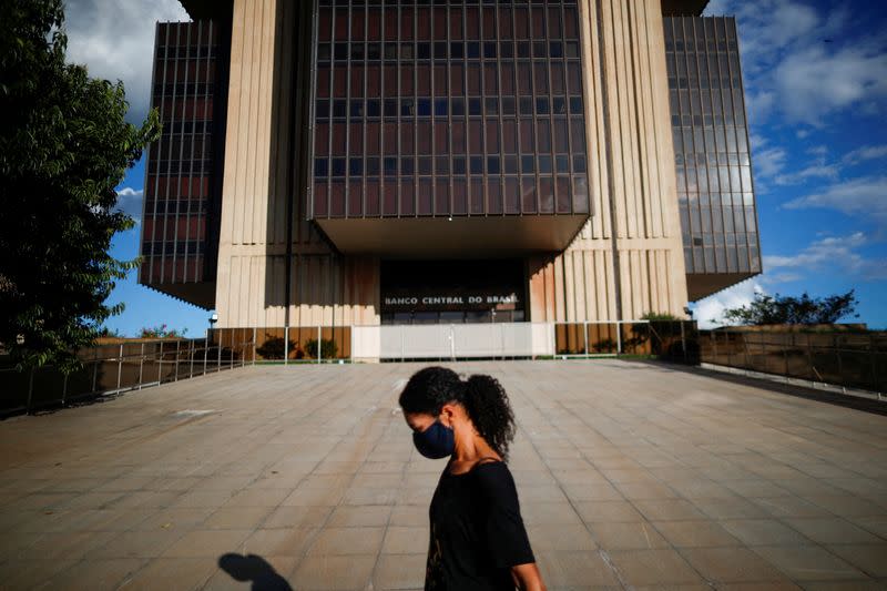 FILE PHOTO: A woman walks in front the Central Bank headquarters building in Brasilia