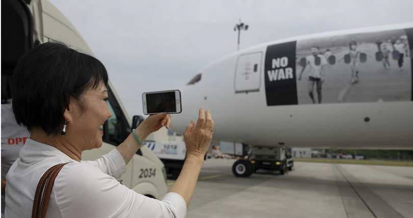燒夷彈女孩照片被印在飛機上，潘金福用手機做記錄。