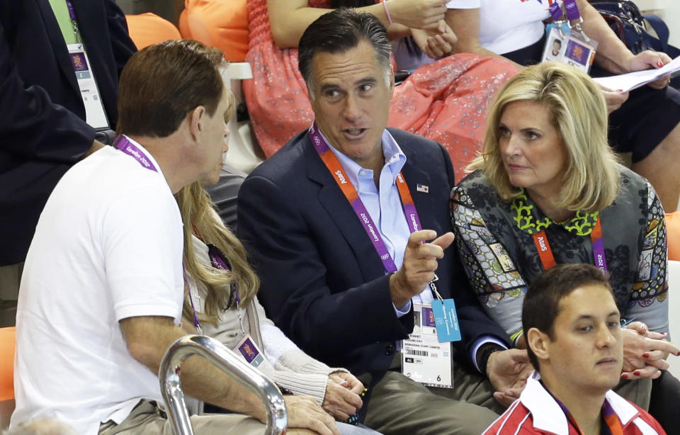 United States Republican presidential candidate Mitt Romney, center, and his wife Ann, right, talk to unidentified spectators on the opening day of swimming competitions at the Aquatics Centre in the Olympic Park during the 2012 Summer Olympics in London, Saturday, July 28, 2012. (AP Photo/Lee Jin-man)