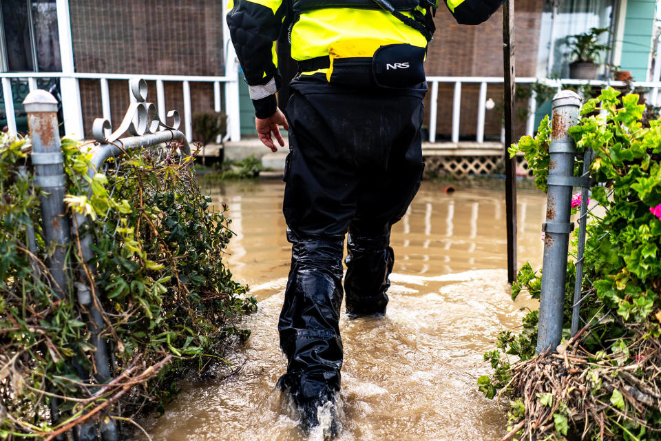 Water rescue officer Gino Degraff walks through flooded Pajaro neighborhood streets checking on residents who have not evacuated since a levy breech flooded the community, on March 13, 2023.