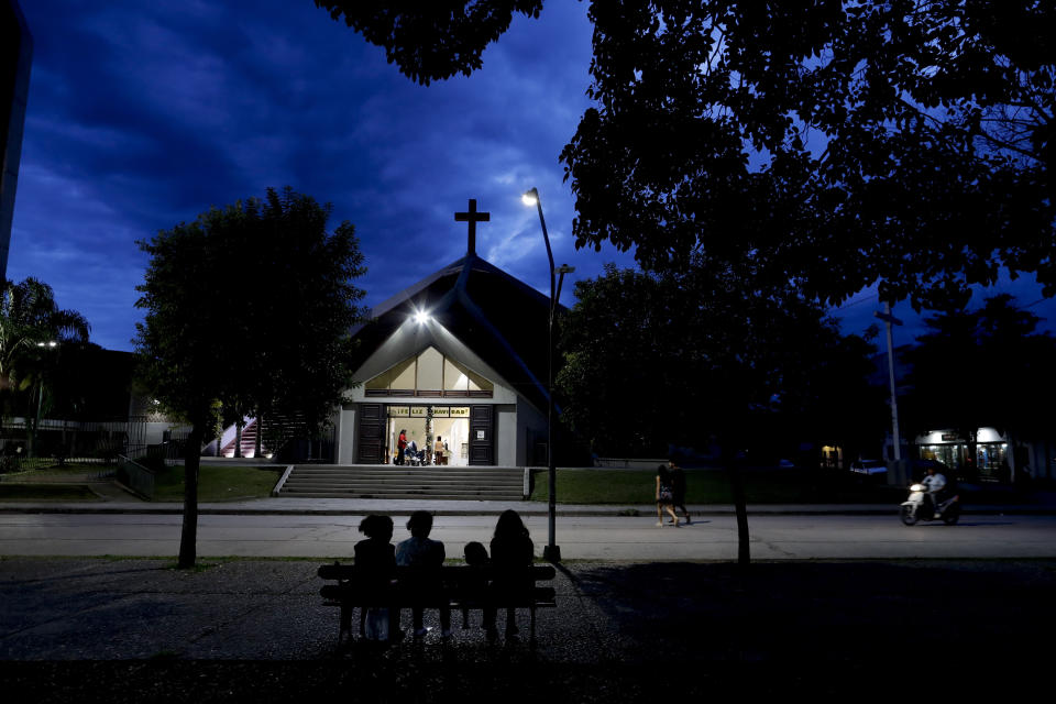 People sit outside the Cathedral in Oran, Argentina, Wednesday, Jan. 16, 2019. Pope Francis accepted former Oran's Bishop Gustavo Zanchetta's resignation in 2017 after priests in the remote northern Argentine diocese of Oran rebelled under his authoritarian rule and sent reports to the Vatican embassy alleging abuse of power and sexual abuses with adult seminarians, according to the former vicar, Rev. Juan Jose Manzano. (AP Photo/Natacha Pisarenko)