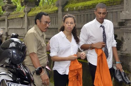 A court bailiff escorts U.S. citizens Tommy Schaefer (R) and his girlfriend Heather Mack (C), the daughter of U.S. woman Sheila von Wiese-Mack, who was found dead inside a suitcase on the Indonesian holiday island of Bali, as they walk to their trial at a Denpasar court in Bali January 28, 2015 in this photo taken by Antara Foto. REUTERS/Antara Foto/Wira Suryantala