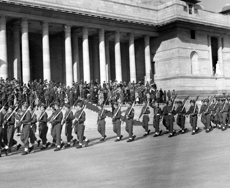 Last British Troops in India: Britain’s Earl Mountbatten, in naval uniform,centre, salutes the colours during the farewell march past of the last battalions of the British Army, stationed in Delhi, in the forecourt of Government House, Delhi, Dec. 19, 1947. The last battalions are from the Royal Scots Fusiliers and the East Lancashire regiments. (AP Photo)