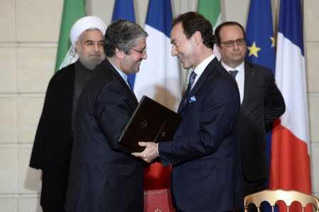 Airbus chief executive Fabrice Bregier (R), Iran Air chief Executive Farhad Parvaresh (L), Iranian President Hassan Rouhani (rear L) and French President Francois Hollande attend a bilateral political, cultural and economic agreements signing ceremony at the Elysee Palace in Paris, France, January 28, 2016.REUTERS/Stephane De Sakutin/Pool/Files