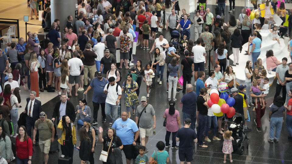 Travelers walk through crowds after arriving at the Salt Lake City International Airport Friday, June 30, 2023, in Salt Lake City. (AP Photo/Rick Bowmer)