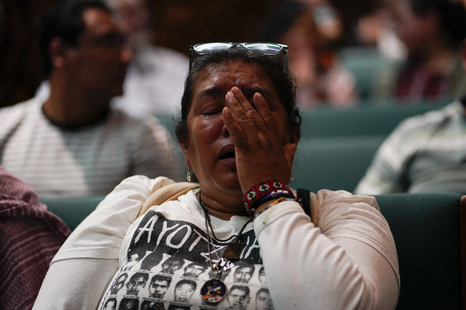 A family member of the 43 missing students from Ayotzinapa, wipes away tears as she attends a presentation of a report by the Interdisciplinary Group of Independent Experts (GIEI), in Mexico City, Tuesday, July 25, 2023. The GIEI presented its sixth report on the case of the missing students who disappeared on Sept. 26, 2014. (AP Photo/Eduardo Verdugo)