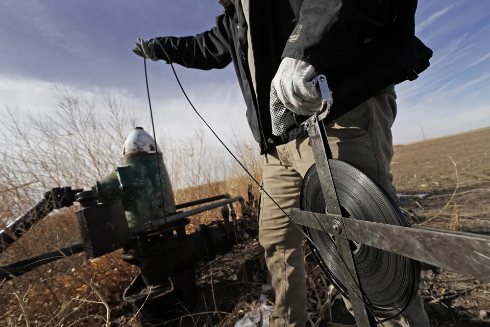 Kansas Geological Survey field research technician Connor Umbrell measures water levels in an irrigation well Thursday, Jan. 5, 2023, near Marienthal, Kan. Lawmakers are looking to take up groundwater issues in western Kansas in the upcoming session as the Kansas Water Authority is urging stricter usage measures to try to slow the steady decline of water levels in the Ogallala Aquifer. (AP Photo/Charlie Riedel)